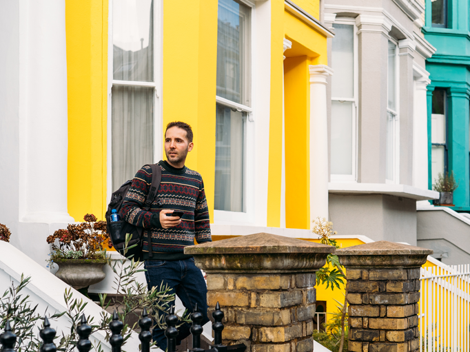 A man walking out of a colourful house
