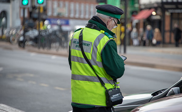 Civil enforcement officer looking at his mobile device